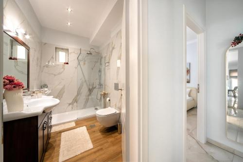 Un baño blanco con lavabo y ducha. en Evis coastal comfort house, en Kalamaki