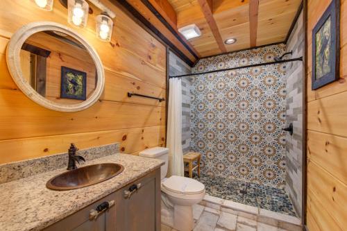 a bathroom with a toilet sink and a mirror at Red Cedar Lodge By Avada Properties in Sevierville