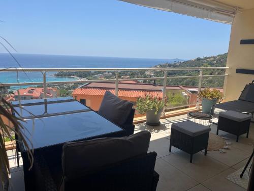 a balcony with a table and chairs and the ocean at Appartement T2 vue sur les sanguinaires in Ajaccio