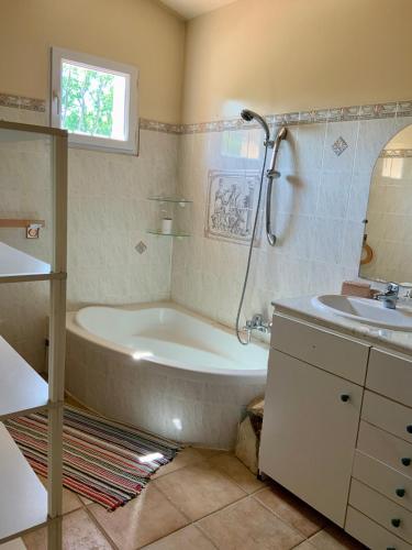 a bathroom with a tub and a sink at Villa provençale La Banisté in Saint-Cézaire-sur-Siagne