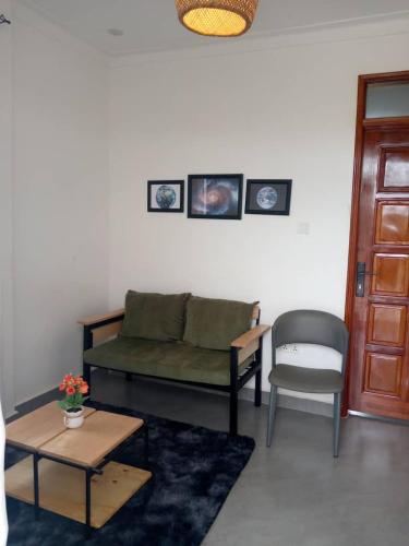 a living room with a green couch and a chair at Zaya Residency in Kampala