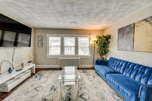 a living room with a blue couch and a table at Walk to River and Downtown Portsmouth Apartment! in Portsmouth