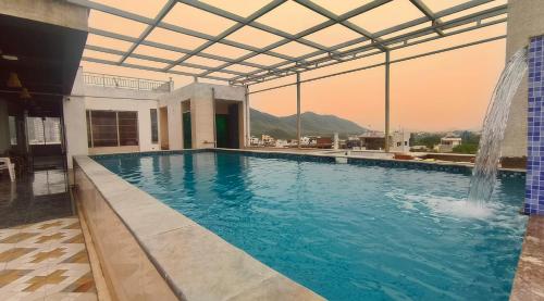 - une piscine avec une fontaine dans un bâtiment dans l'établissement Hotel Hill View By Heritage inn, à Udaipur
