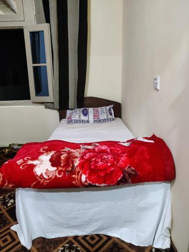 a bed with a red blanket on top of it at K6 Hotel & Camping Kande in Kande