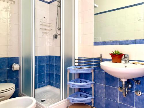 y baño de azulejos azules con lavabo y ducha. en Residence Carioca, en Rímini