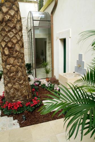 a palm tree in a garden next to a building at Hotel Novecento in Scicli