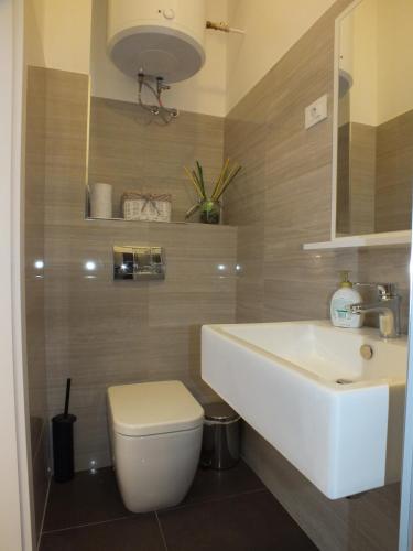 a bathroom with a white sink and a toilet at Apartman Draguć in Pula