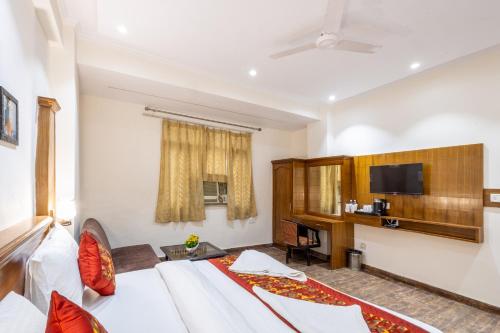 a hotel room with a bed and a tv at Hotel Garden View - Near Karol Bagh Metro Station and Gaffar Market in New Delhi