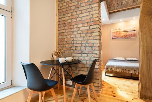 a room with two chairs and a table in front of a brick wall at Premium Basement Apartament by Vibe Hostel in Sopot