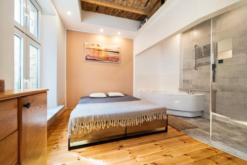 a bedroom with a bed and a bath tub and a shower at Premium Basement Apartament by Vibe Hostel in Sopot