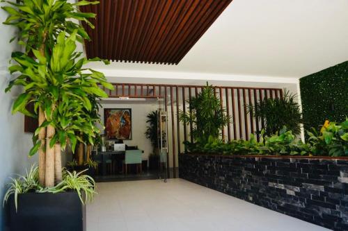 a lobby with plants and a table in the distance at Elegance on Fifth Avenue in Playa del Carmen