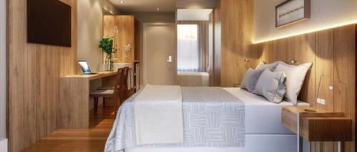 una camera da letto con un letto, una scrivania e un computer di Golden Tulip Canela a Canela