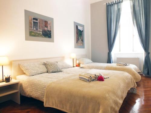 two beds sitting in a bedroom with a window at Apartman Draguć in Pula