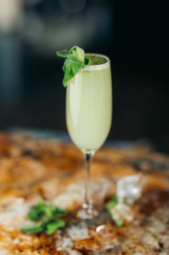 a glass of white drink with a mint leaf in it at Hotel Rio Guayas by Art Hotels in Guayaquil