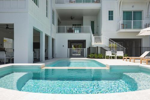 a swimming pool in front of a building at New Waterfront Home - Dreamside House in Key West