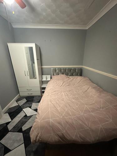 a bedroom with a bed and a dresser and a mirror at Double room in a shared house in Chatham