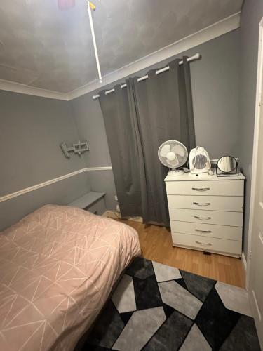 a bedroom with a bed and a dresser in it at Double room in a shared house in Chatham