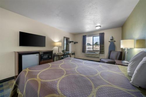 a hotel room with a bed and a flat screen tv at SureStay by Best Western Walla Walla in Walla Walla
