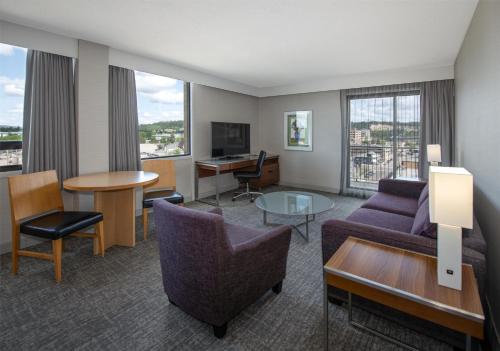 a living room with a couch and a table at Coast Prince George Hotel by APA in Prince George