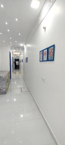 a hallway of a room with white walls and ceilings at The Host By Amaris in Amritsar
