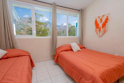two beds in a room with a window at NEW Bamboo Mystic Mountain Culture and Peace in Tepoztlán
