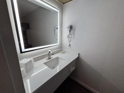un bagno bianco con lavandino e specchio di Motel 6 Conway, SC a Conway