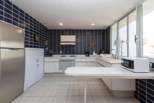 a kitchen with white appliances and blue tiles at NEW Bamboo Mystic Mountain Culture and Peace in Tepoztlán