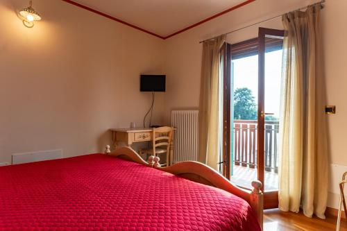 a bedroom with a red bed and a sliding glass door at Hotel & Restaurant AL TRIVIO in Altana