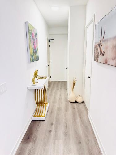 a hallway with white walls and a yellow and white chair at Bright & Cozy 1 Bedroom Retreat in Vaughan