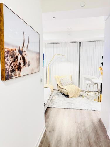 a living room with a picture of a cow on the wall at Bright & Cozy 1 Bedroom Retreat in Vaughan