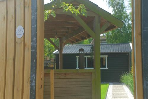a wooden garage door with a wooden pergola at De Blokhut in Anna Paulowna