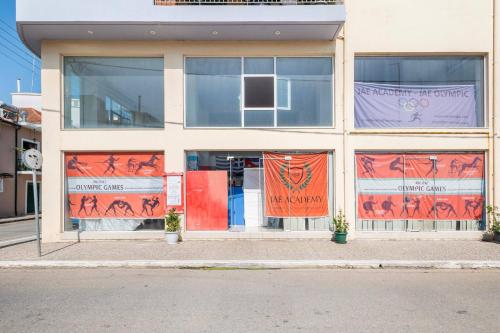 a building with banners in the windows of it at Charming Studio in Amaliada, Greece with Private Entrance in Amaliás
