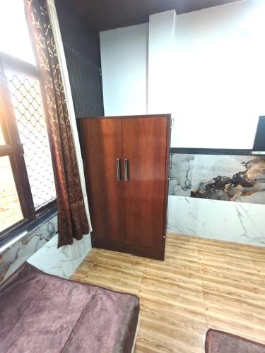 a room with a wooden cabinet and a wooden floor at PARADISE VILLA "Lord Krishna's Inn" in Vrindāvan