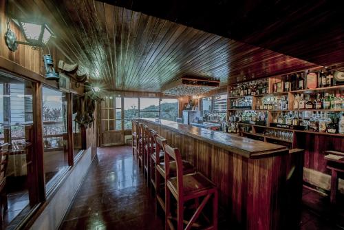 a bar with a wooden counter and chairs in a room at Hotel Montaña Monteverde in Monteverde Costa Rica