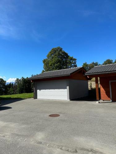 a garage with a white garage door next to a house at PetitChevrier - 6BR Spacious Chalet in Villars - Designed for Accessibility in Ollon