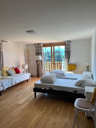 a large bedroom with two beds and a large window at PetitChevrier - 6BR Spacious Chalet in Villars - Designed for Accessibility in Ollon
