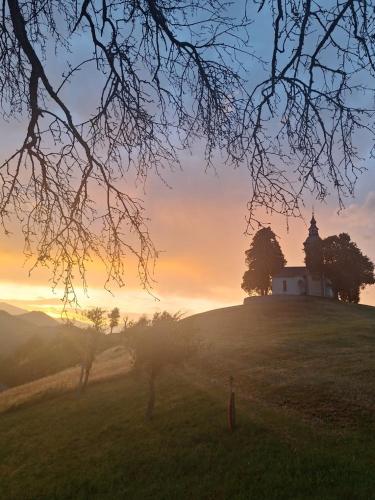 a church on top of a hill with the sunset at Apartma Saint Thomas in Selca