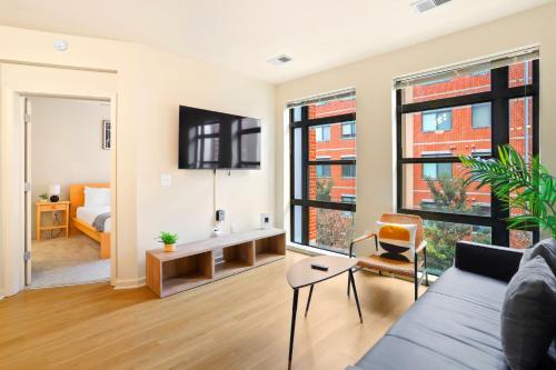 a living room with a couch and a bedroom at Comfort & Convenience in Trendy Crystal City Loft in Arlington