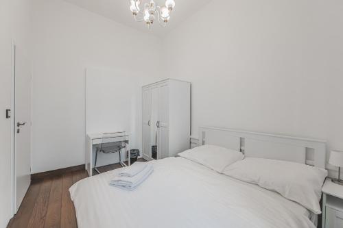 a white bedroom with a bed and a desk at Heart of Prague Lodgings 6 in Prague