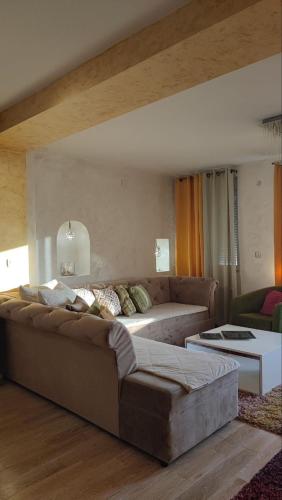 a living room with a large couch and a table at Rezevici AZUR in Budva