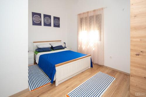 une chambre avec un lit avec des draps bleus et une fenêtre dans l'établissement 369 Apartment, à Kotor