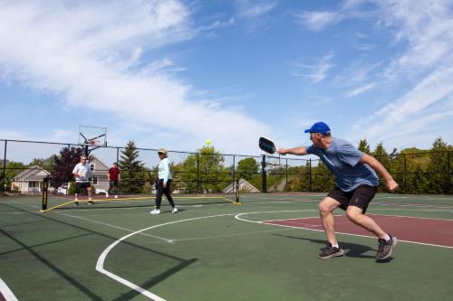 a man swinging a tennis racket on a tennis court at The Marmot - 12 Butternut in Cherry Valley