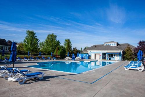 a swimming pool with lounge chairs and umbrellas at The Marmot - 12 Butternut in Cherry Valley