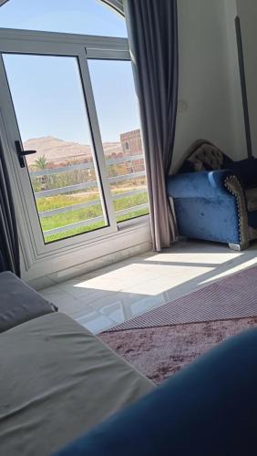 a bedroom with a bed and a large window at Villa Saeed in Al Karnak