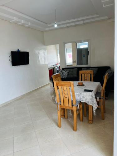 a living room with a table and chairs and a couch at Appartement neuf, à côté de la Mer in Oualidia