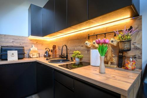 a kitchen counter with flowers in a vase on it at Dziupla House in Czarna