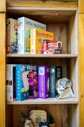 a book shelf filled with lots of books at Dziupla House in Czarna
