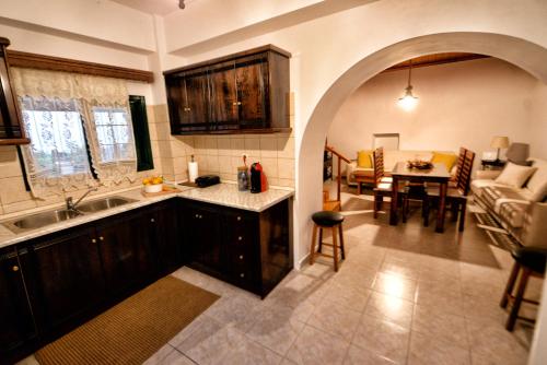 cocina y sala de estar con sofá y mesa en Ermioni's Cottage by Konnect, Agios Markos, en Ágios Márkos