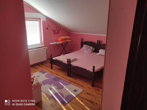 a bedroom with a bed in a pink room at Kuća za odmor Matić in Bajina Bašta