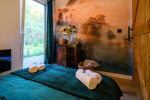 a bedroom with a bed with towels on it at Dziupla House in Czarna